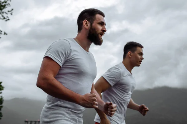 Morgon träning, idrottsmän som springer i bergen lever hälsosam livsstil — Stockfoto