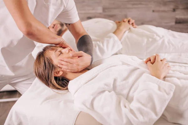 Beauty woman is getting head massage while her husband lying on the bed — Stock Photo, Image