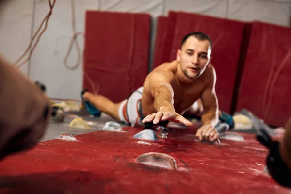 Escalador profesional masculino en el entrenamiento interior en el centro de bouldering. — Foto de Stock