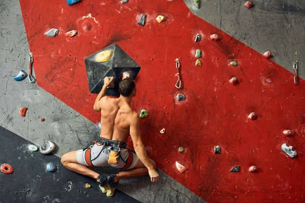 Escalador profissional masculino no treino indoor no centro de pedregulhos . — Fotografia de Stock