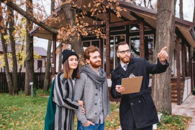 Yeni ev alan genç beyaz çiftli emlakçı.