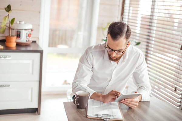 Serious applicant sitting in boardroom, preparing for interview with employer.