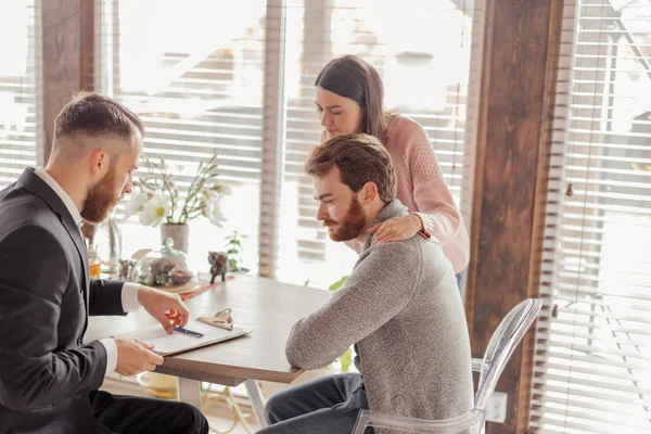 Familiepaar in gesprek met agent in functie, kopen, huren appartement of huis. — Stockfoto