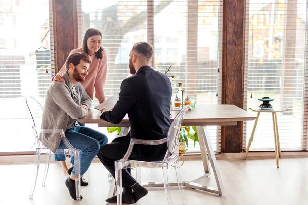 Familiepaar in gesprek met agent in functie, kopen, huren appartement of huis. — Stockfoto