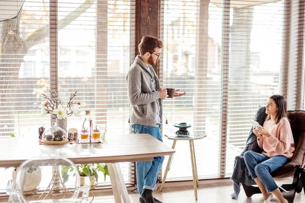 Pareja joven pasando la mañana en un nuevo hogar, discutiendo sus planes para el futuro —  Fotos de Stock