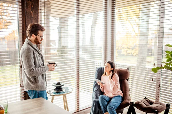 Pár a konyhában időt töltenek együtt egy csésze kávé és okostelefon — Stock Fotó