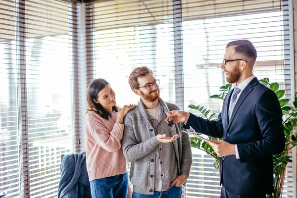 Pareja de clientes firmando papeles con corredor de hipotecas haciendo acuerdo de compra — Foto de Stock