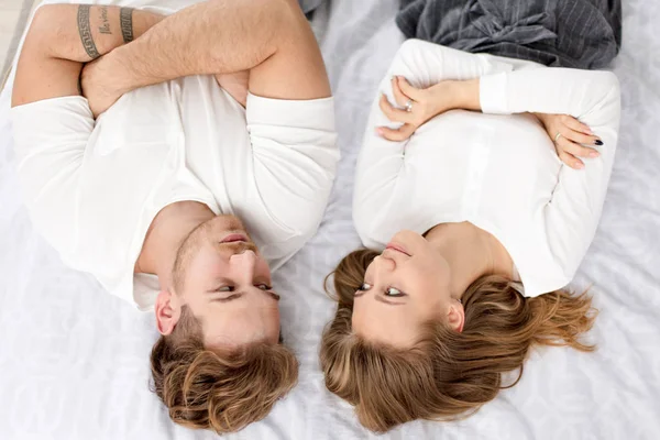 Dois jovens loiros deitados na cama com os braços cruzados e olhando um para o outro — Fotografia de Stock