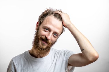 Tatmin olmuş yakışıklı adam beyaz arka planda izole edilmiş kameraya gülümsüyor..