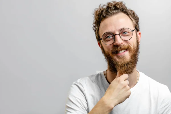 Vriendelijk positieve man kijkt naar camera met twijfelachtige, twijfelachtige uitdrukking. — Stockfoto