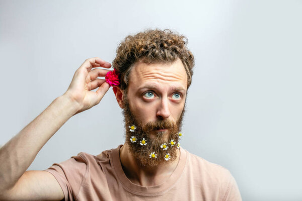 Удовлетворенный веселый красивый мужчина улыбается в камеру на белом фоне.