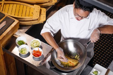 ateş en iyi görünümü kapatın. çubuklarla makarna almaya çalışan Şef