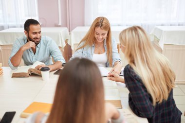 Bir grup üniversite kitaplığında kitaplarla eğitim çok ırklı insan.