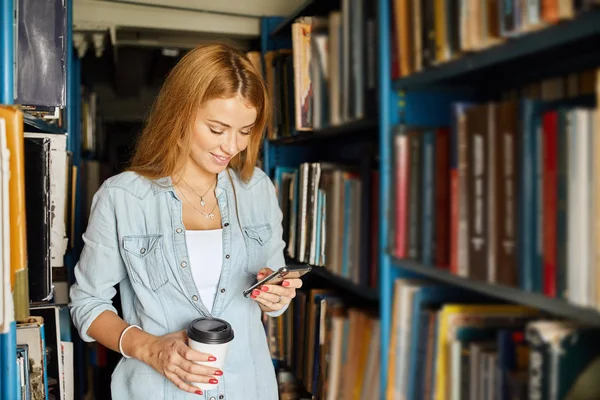 Blonďatá učitelka vyhledávání knih v knihovně, ve škole — Stock fotografie