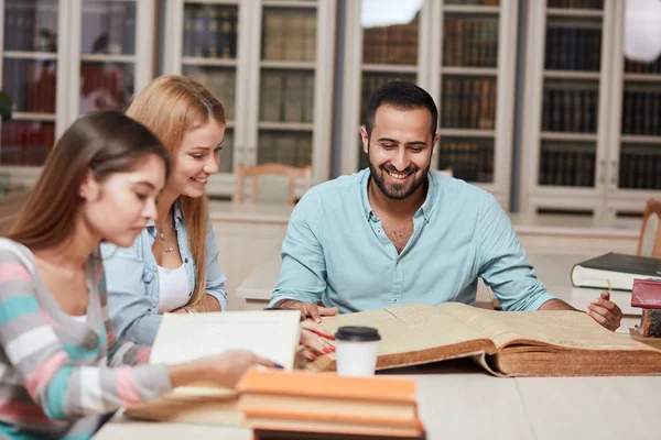 Grupo de personas multirraciales que estudian con libros en la biblioteca universitaria . — Foto de Stock