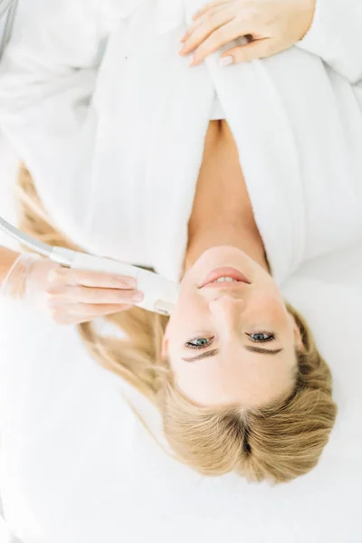 Donna bionda con i capelli lunghi fa viso laser resurfacing al centro di bellezza — Foto Stock