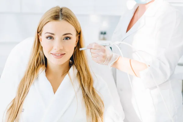 Blonde woman undergoes a procedure of facial gas-liquid oxygen peeling — Stock Photo, Image