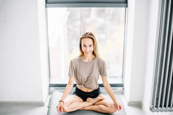 Alegre joven con ropa casual sentada con las piernas extendidas — Foto de Stock