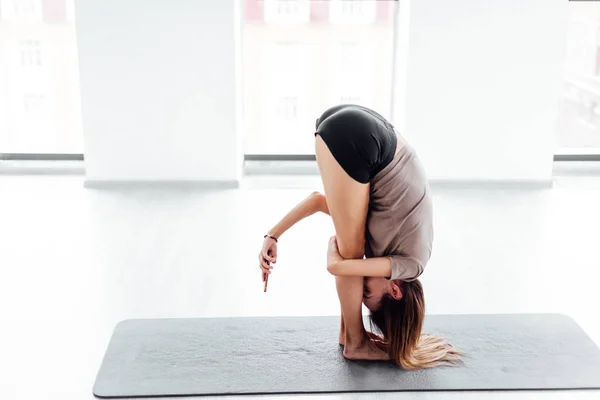 Drôle ajustement fille à l'aide de son smartphone tout en faisant du yoga — Photo