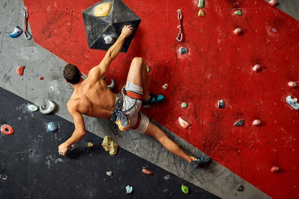 Male professional climber at indoor workout at bouldering centre. — Stock Photo, Image