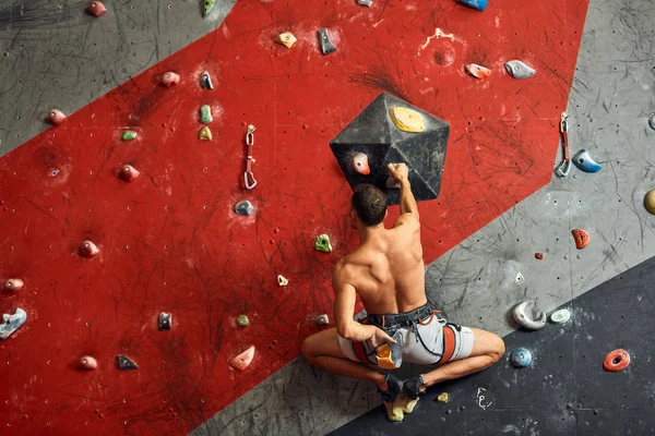 Escalador profesional masculino en el entrenamiento interior en el centro de bouldering. —  Fotos de Stock