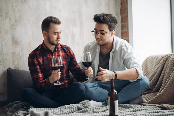 Riendo pareja gay macho bebiendo vino y preparando una comida — Foto de Stock