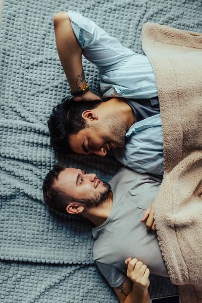 침대에 누워 잘 자는 남자 친구와 활발 한 키스를 하는 점잖은 졸린 남자 — 스톡 사진