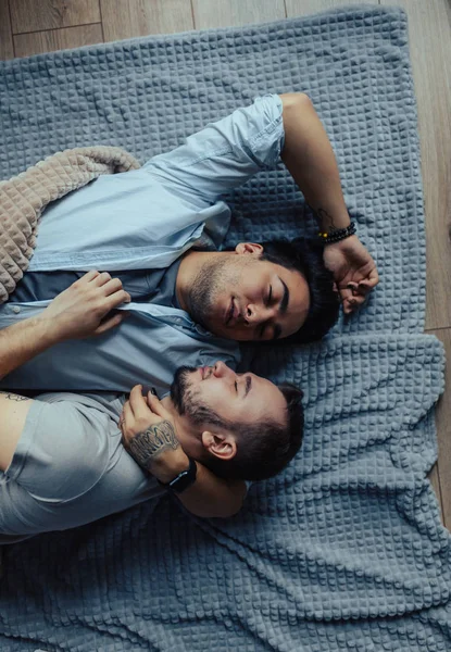 Fešák ospalý muž s štětinatým líbání dobrou noc muž partner ležící v posteli — Stock fotografie