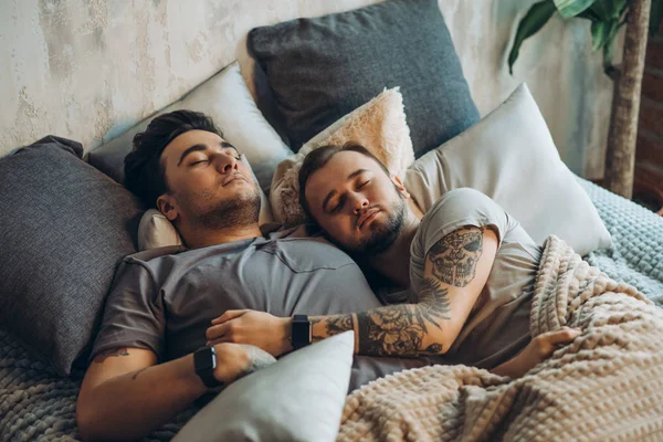 Ett homosexuellt par på sängen i ateljé med loftinredning — Stockfoto