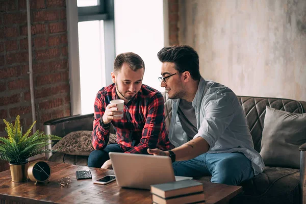 Europees gay man paar besteden tijd samen drinken koffie en kijken laptop — Stockfoto