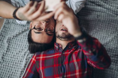 Yatakta selfie çeken eşcinsel çift.