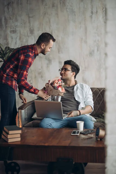 Romantic homo man presenting flowers to his beloved partner, Valentines Day