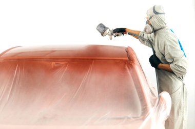 Koruyucu iş kıyafetleri ve solunum cihazında boyacı. Boya odasında araba boyacısı.