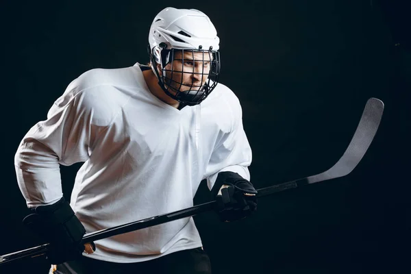 Εικόνα του παίκτη χόκεϊ επί πάγου σε λευκό αθλητικό ντύσιμο κρατώντας μπαστούνι του χόκεϊ — Φωτογραφία Αρχείου