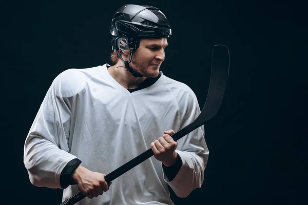 Snygg hockeyspelare. ler mot kameran isolerad på svart bakgrund. — Stockfoto