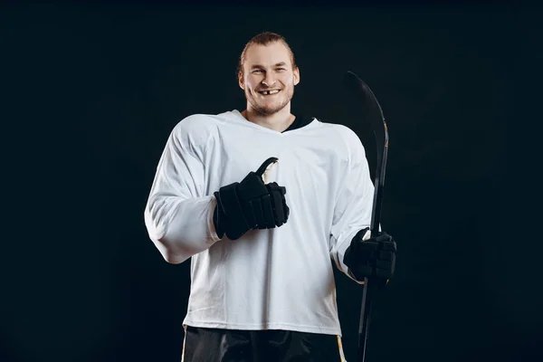 Beau joueur de hockey. Sourire à la caméra isolée sur fond noir. — Photo