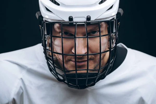 Porträtt av idrottsman i hockey uniform över svart bakgrund — Stockfoto