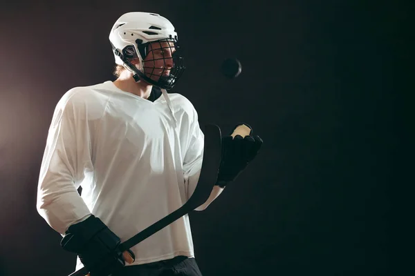 Retrato de jugador de hockey sobre hielo con palo de hockey y disco aislado sobre negro —  Fotos de Stock