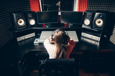 vurdu arka görünümü kapatın. müzik cihazı ile masada oturan genç kadın