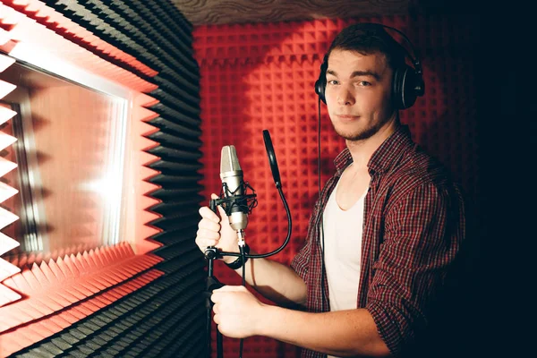 Knappe man gaat zijn nummer opnemen in de studio met de rode muur — Stockfoto