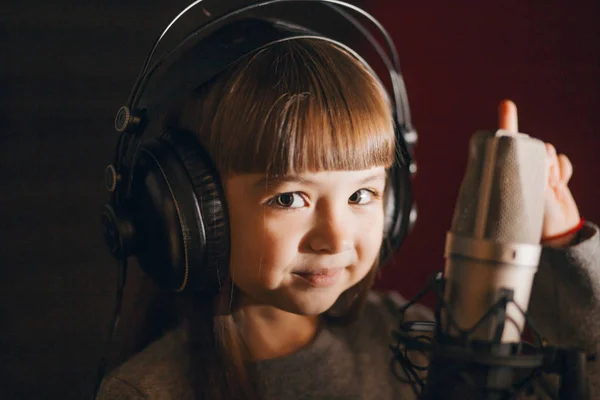 Incrível bela menina com grandes olhos castanhos de pé perto do microfone — Fotografia de Stock