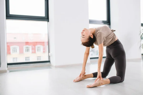 Jeune femme sportive attrayante pratiquant le yoga avec le dos courbé — Photo