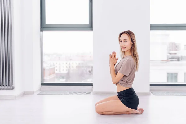 Aantrekkelijk meisje, zittend op de vloer terwijl opleiding yoga — Stockfoto