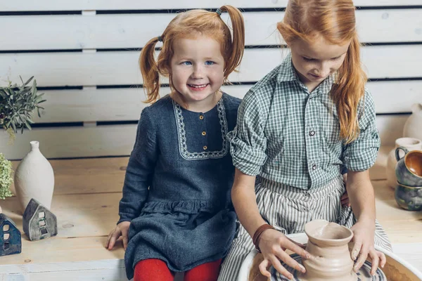 Gelukkig leuke meisjes nemen deel t in de presentatie van klei poort in het kunstatelier. — Stockfoto