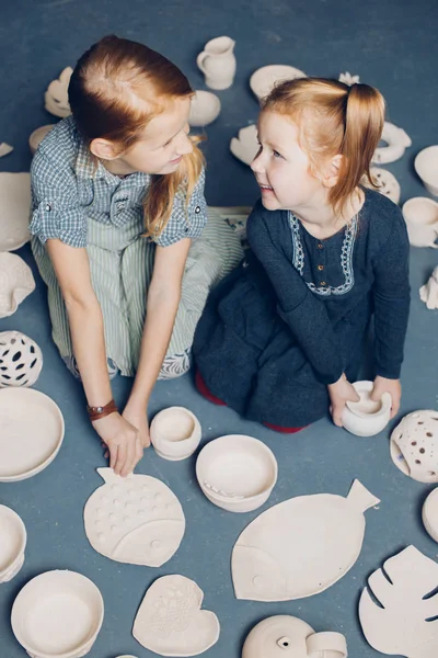 Niños de jengibre riendo disfrutando sentados en el suelo con artesanías —  Fotos de Stock