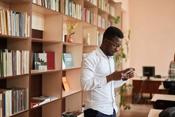 Africano americano estudante universitário do sexo masculino se preparando para exames na biblioteca . — Fotografia de Stock