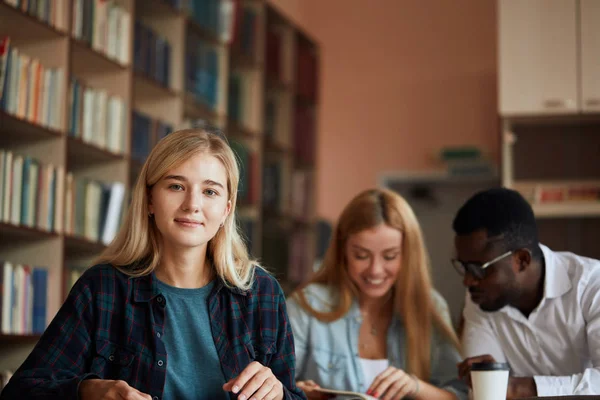 Loira feliz bela mulher estudante frequenta aulas universitárias dentro de casa . — Fotografia de Stock