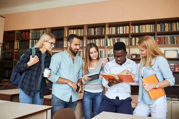 Mnohonárodnostní studenty baví v knihovně při přípravě na zkoušky. — Stock fotografie