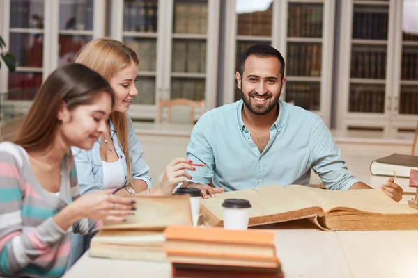 Grupo de personas multirraciales que estudian con libros en la biblioteca universitaria . — Foto de Stock