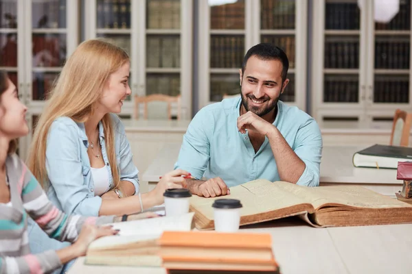 Grupp multiracial människor studera med böcker i college bibliotek. — Stockfoto